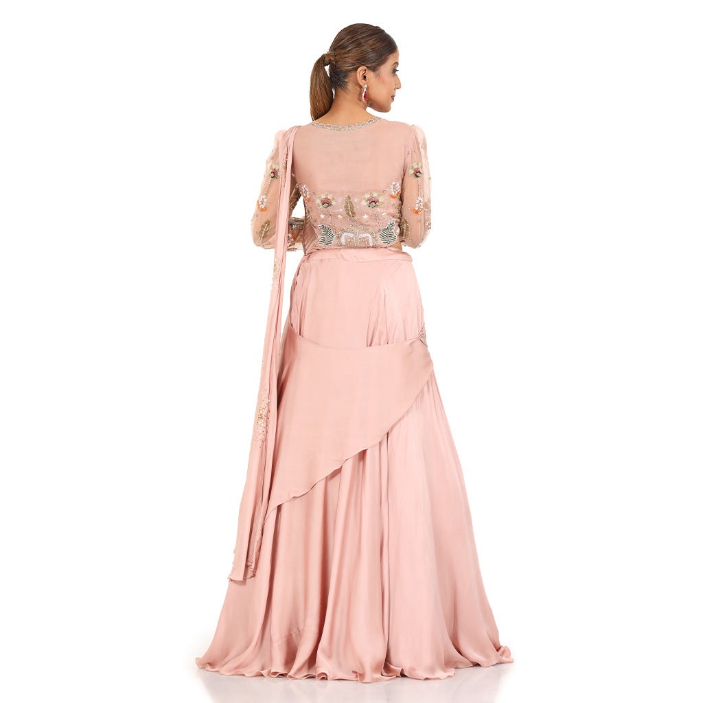 A woman standing and wearing Blush Pink Pearl Drape Lehenga.
