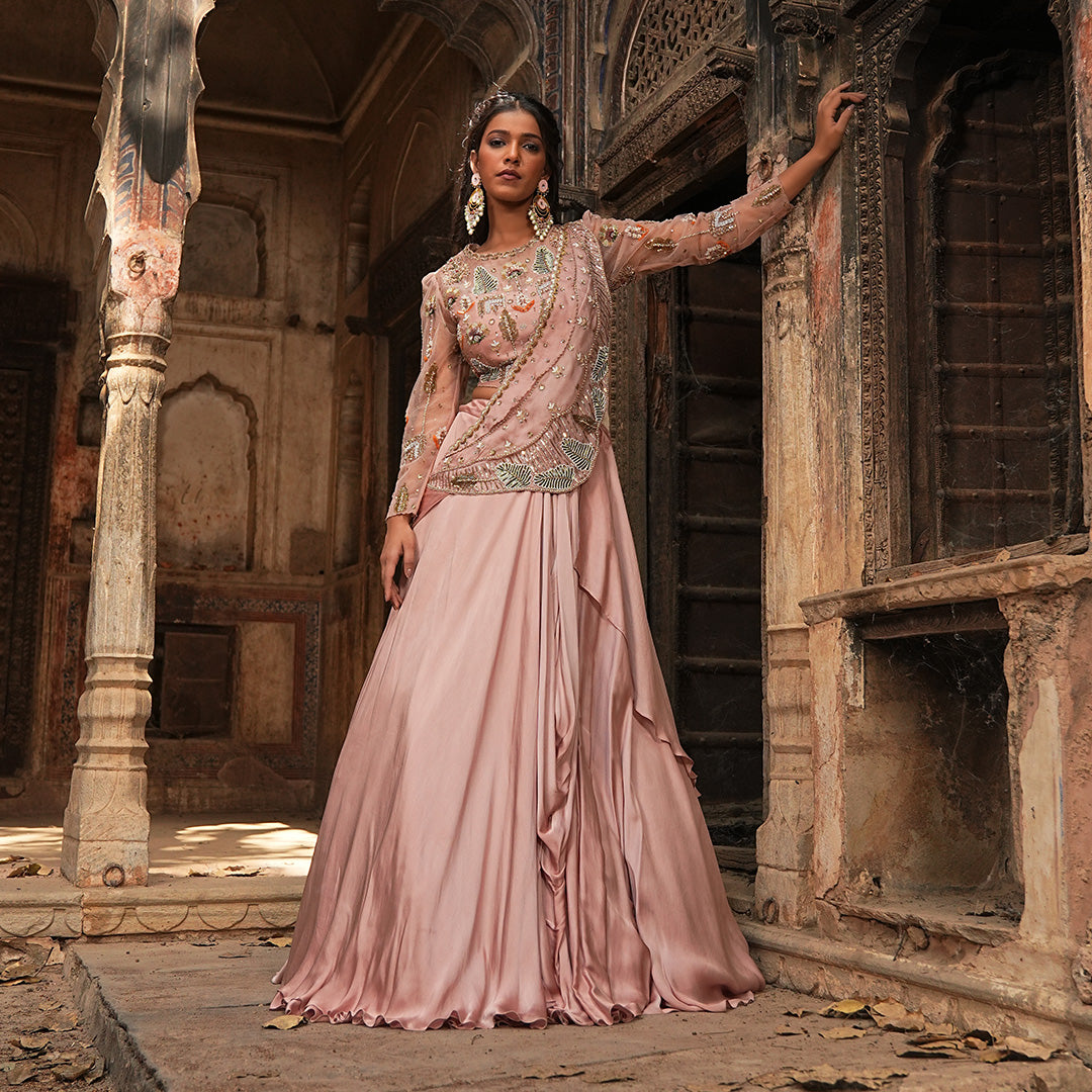 A woman standing and wearing Blush Pink Pearl Drape Lehenga.