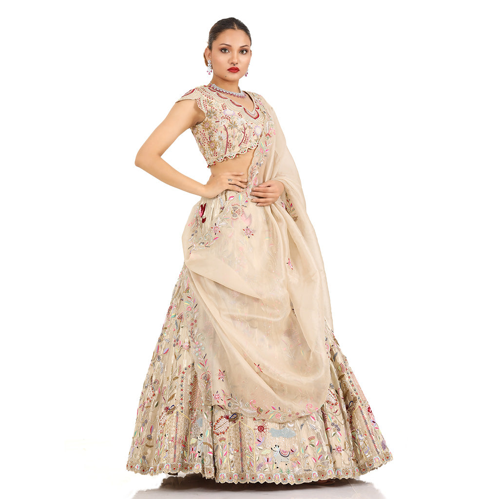 A woman standing and wearing Gold Self Tissue Lehenga Set.