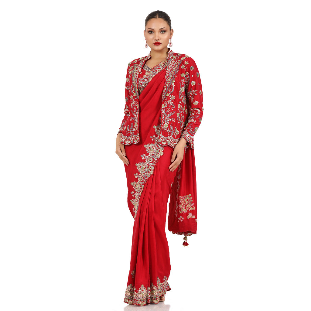 A woman standing and wearing Red Colored Jacket Saree.