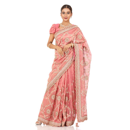 A woman standing and wearing Pink Colored Tissue Jaal Saree.