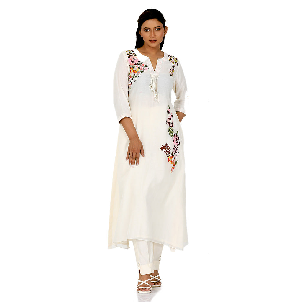 A woman standing and wearing white colored Ivory Floral Placement Kurta Set.