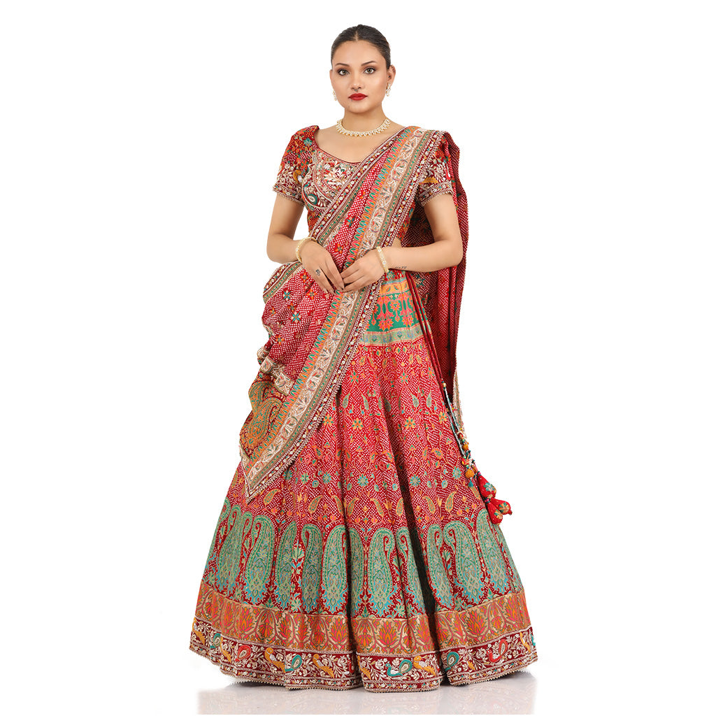 A woman standing and wearing Banarsi Georgette Bandhani Lehenga Set.