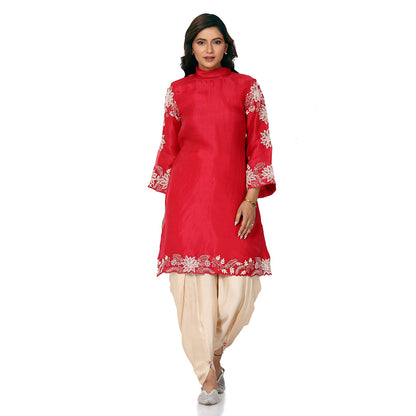 A woman standing and wearing red colored Floral Placement Harem Set.