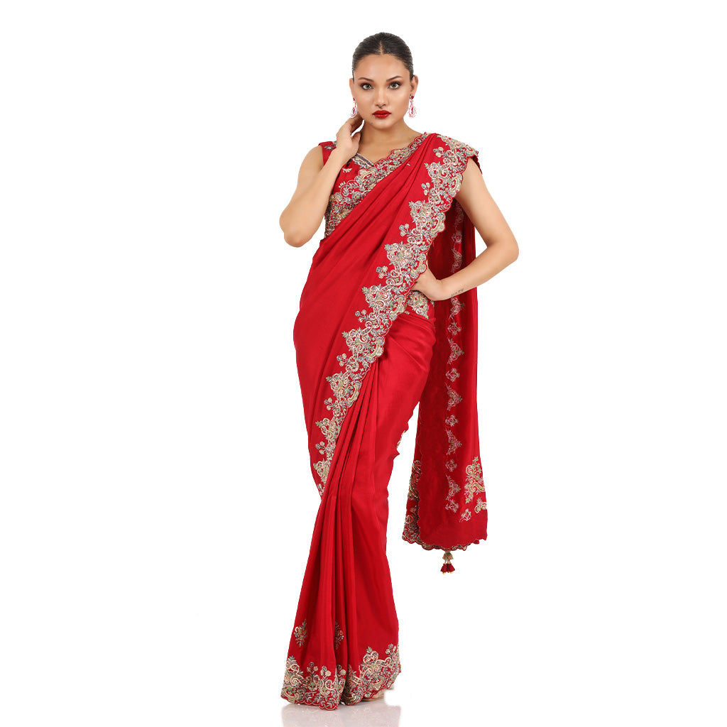 A woman standing and wearing Red Colored Jacket Saree.