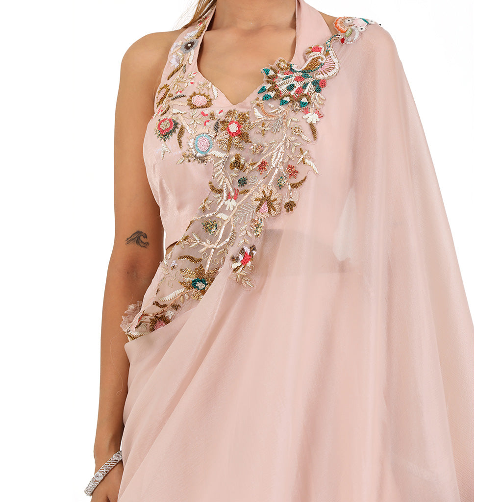 A woman wearing Blush Pink Colored Draped Saree.