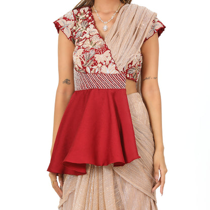 A woman standing and wearing Maroon Colored Peplum Saree.