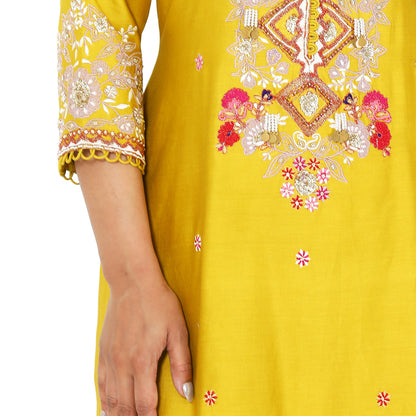 A woman standing and wearing Mustard Colored Kurta with Crush Sharara.