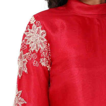 A woman standing and wearing red colored Floral Placement Harem Set.