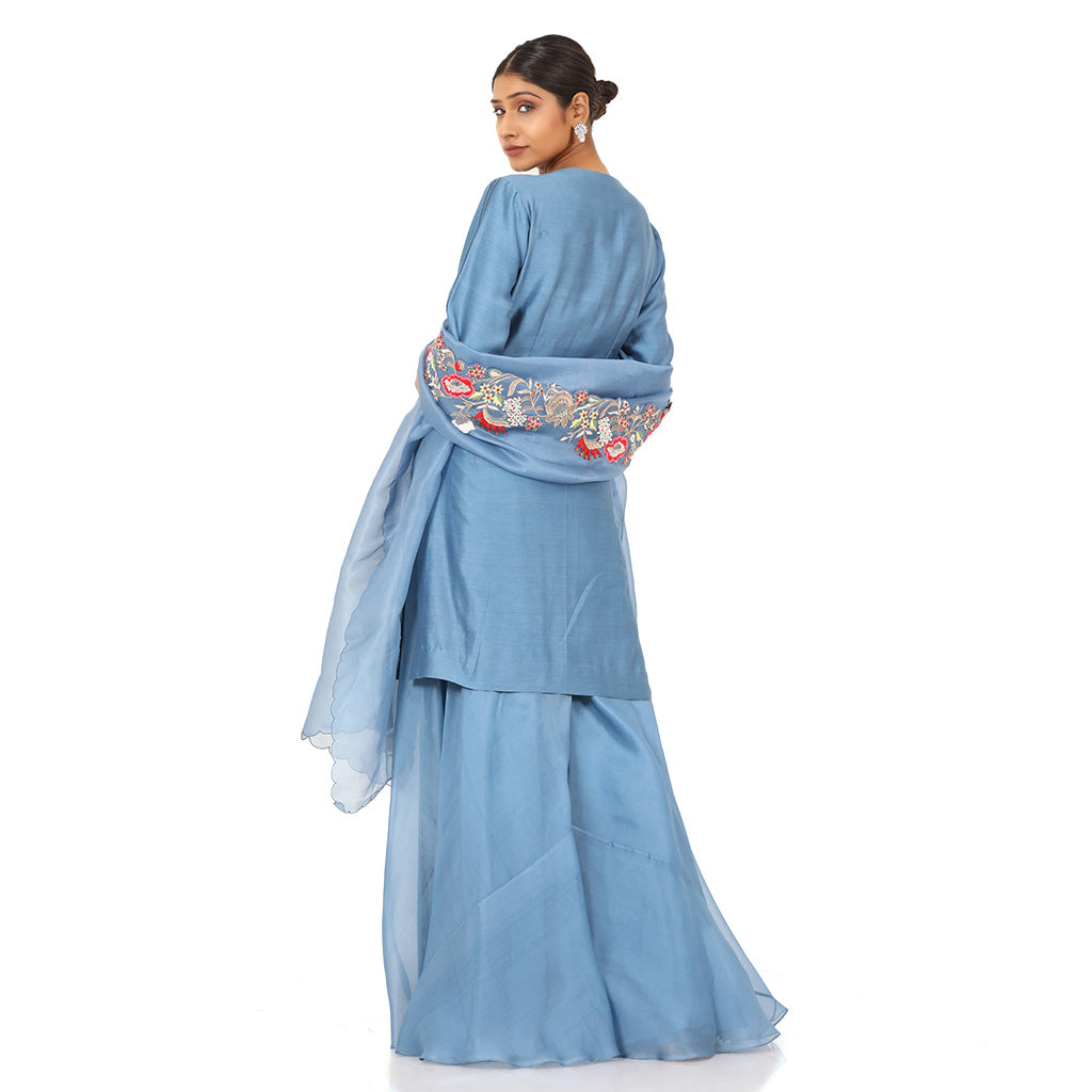 A woman standing and wearing Indigo Blue Pearl Work Kurta Sharara Set.