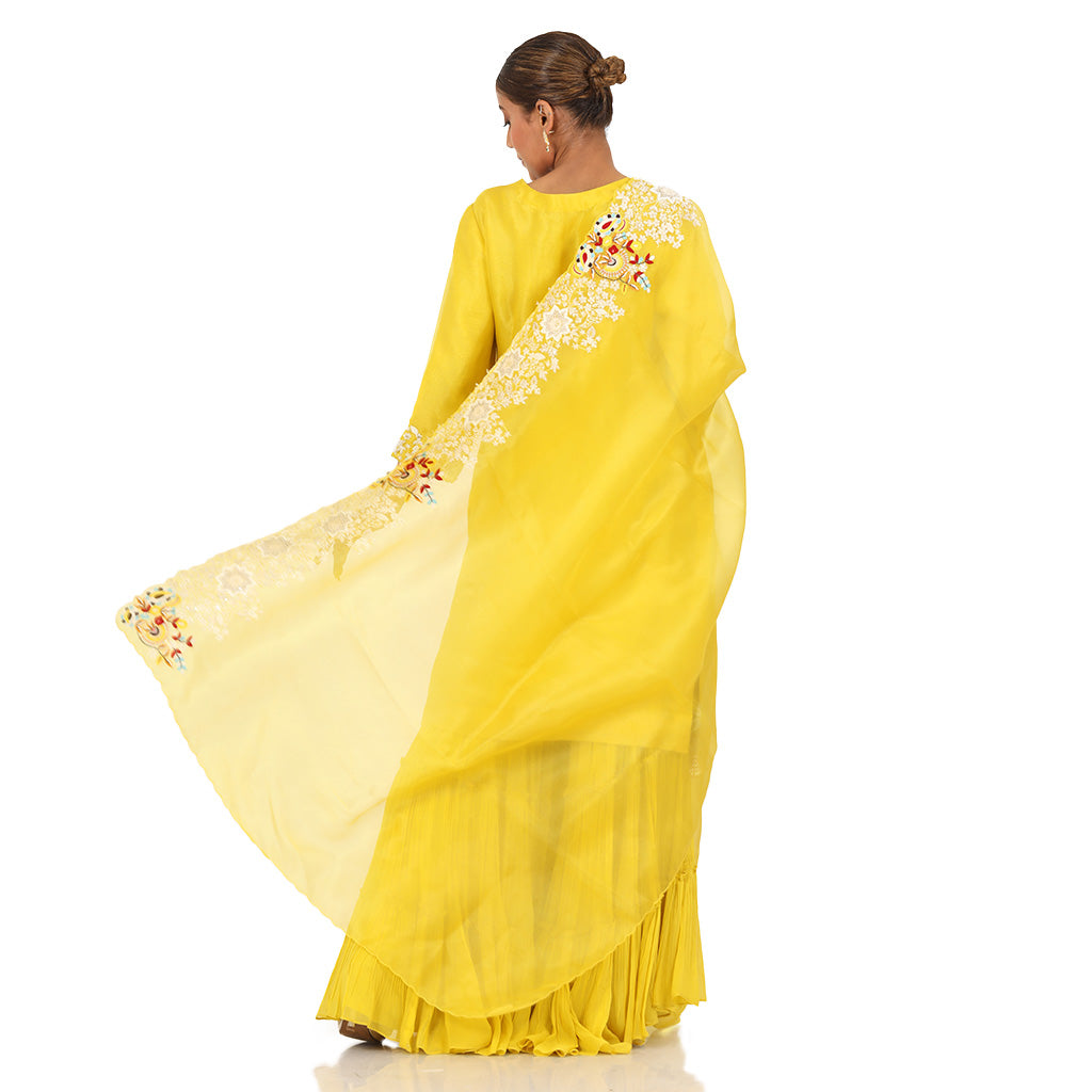  A woman standing and wearing Yellow Pearl Sharara Set.