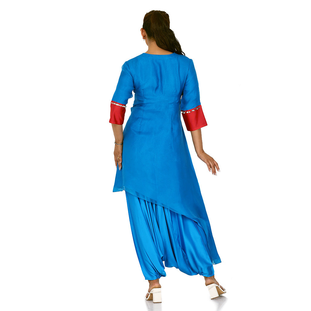 A woman standing and wearing blue colored Side Tail Harem Set with red sleeves.