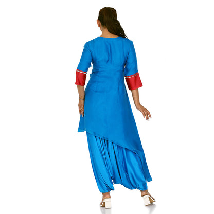 A woman standing and wearing blue colored Side Tail Harem Set with red sleeves.