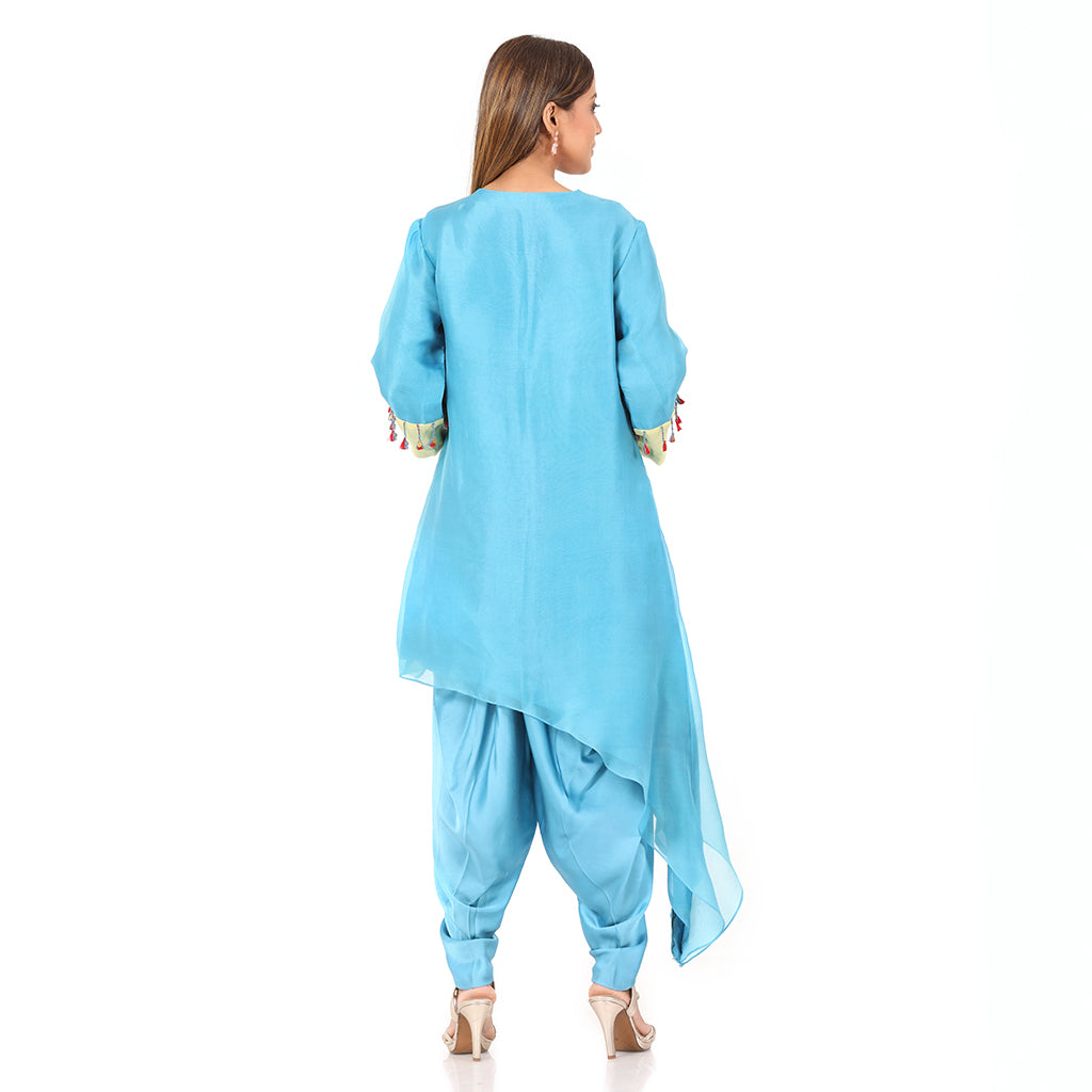 A woman standing and wearing sky blue colored Side Tail Dhoti Set.