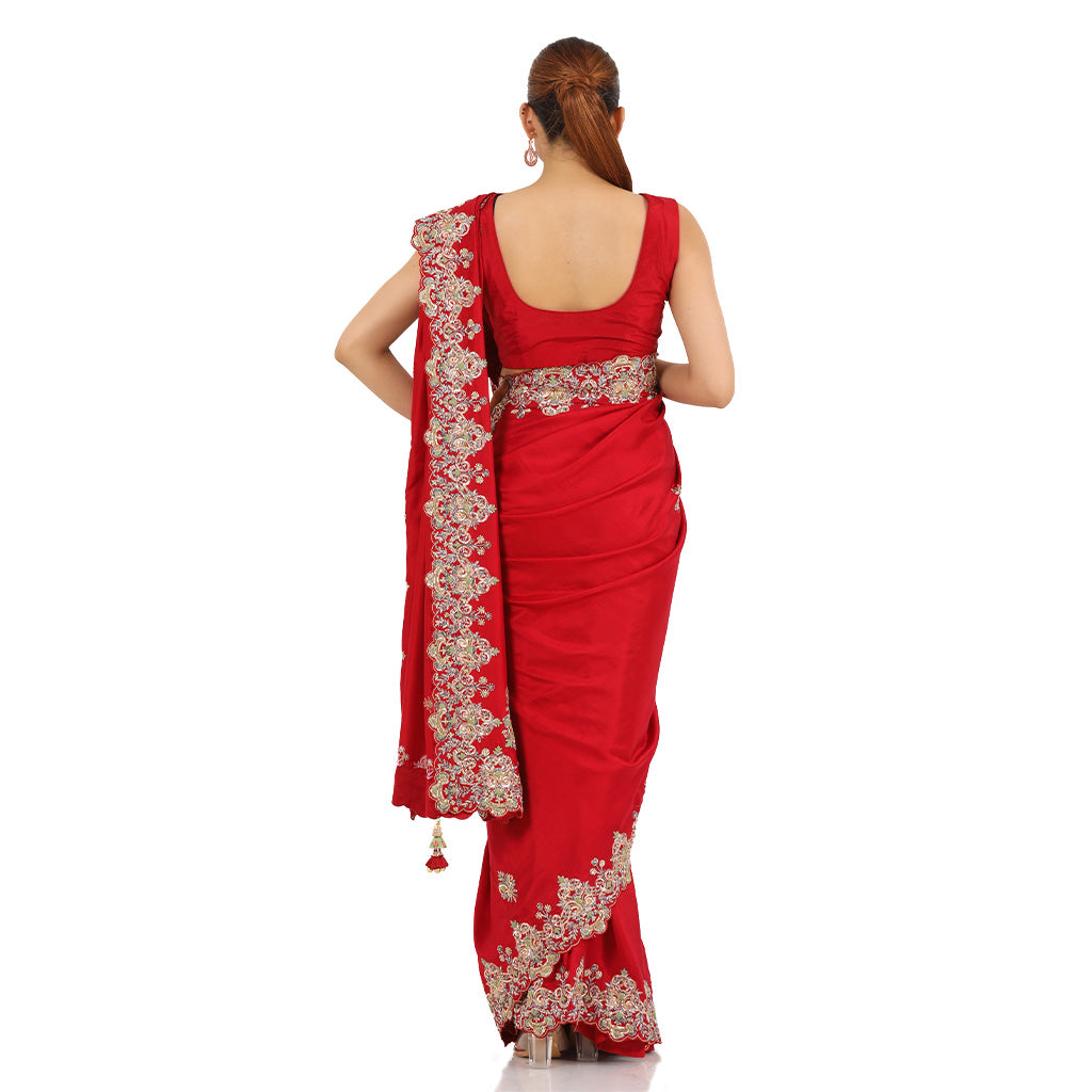 A woman standing and wearing Red Colored Jacket Saree.