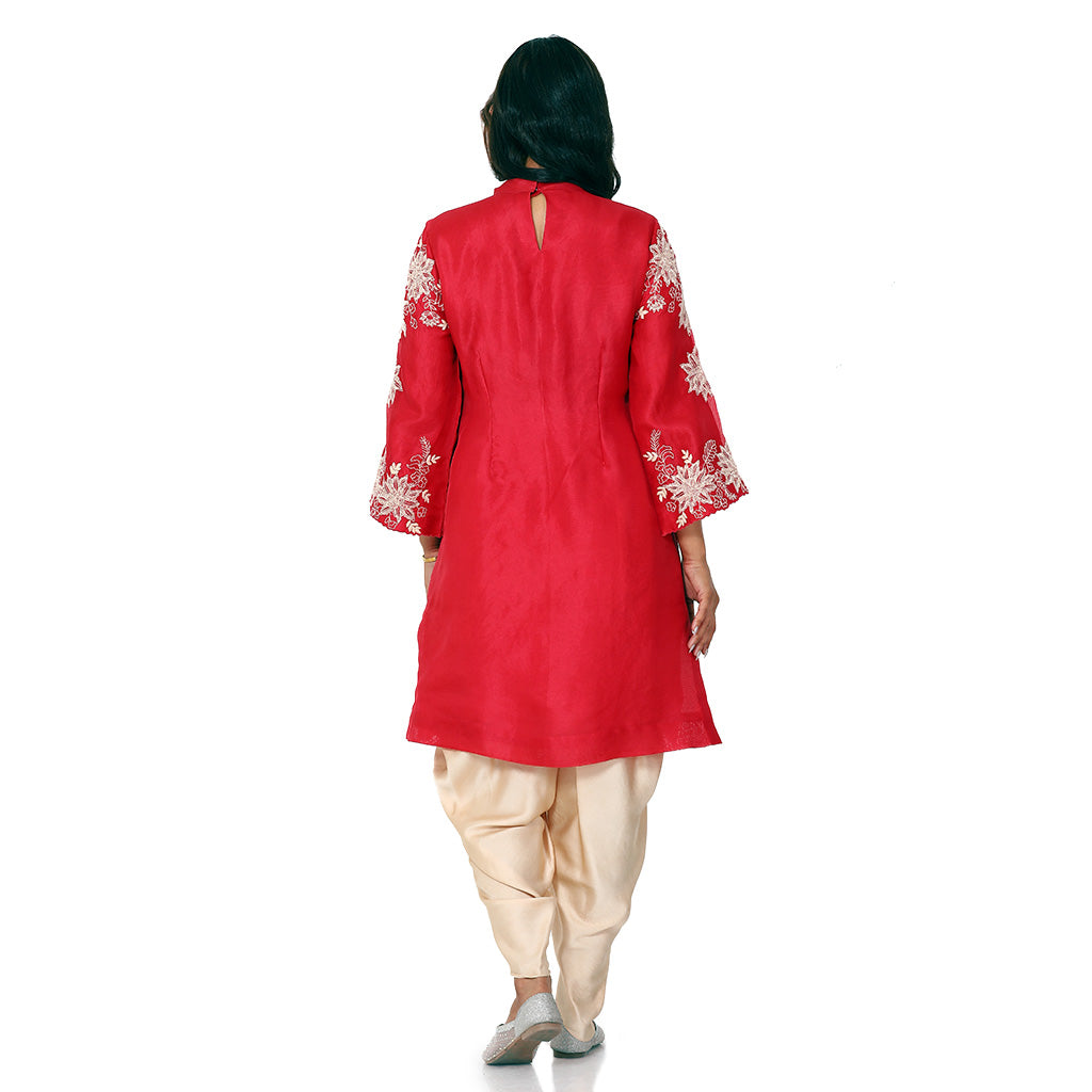 A woman standing and wearing red colored Floral Placement Harem Set.