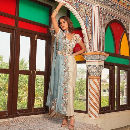 A woman standing and wearing Beige Colored Pant Style Saree.