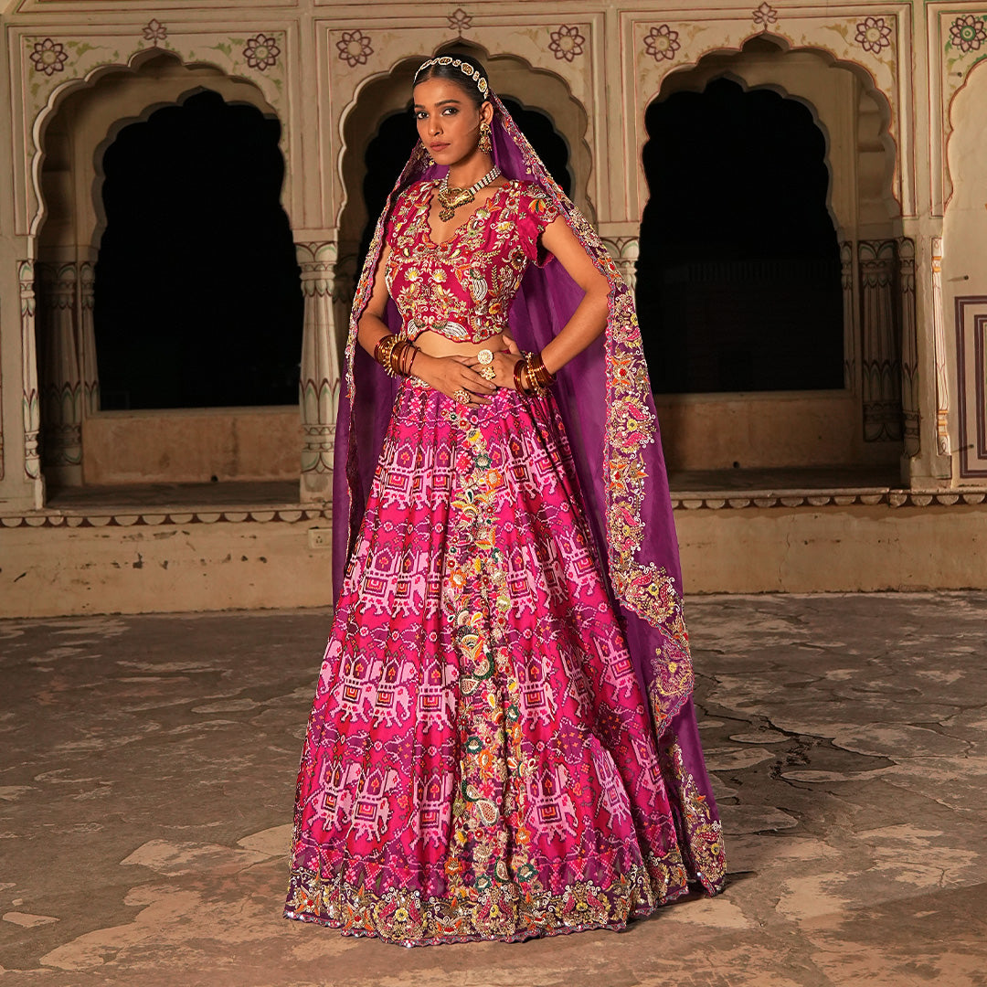 A woman wearing Elephant Motif Patola Lehenga.