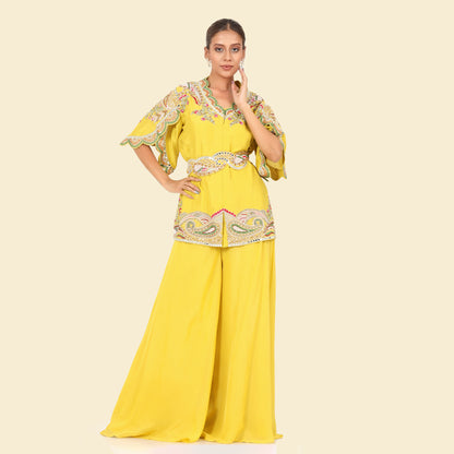 A woman standing and wearing Mustard Colored Kurta with Crush Sharara.