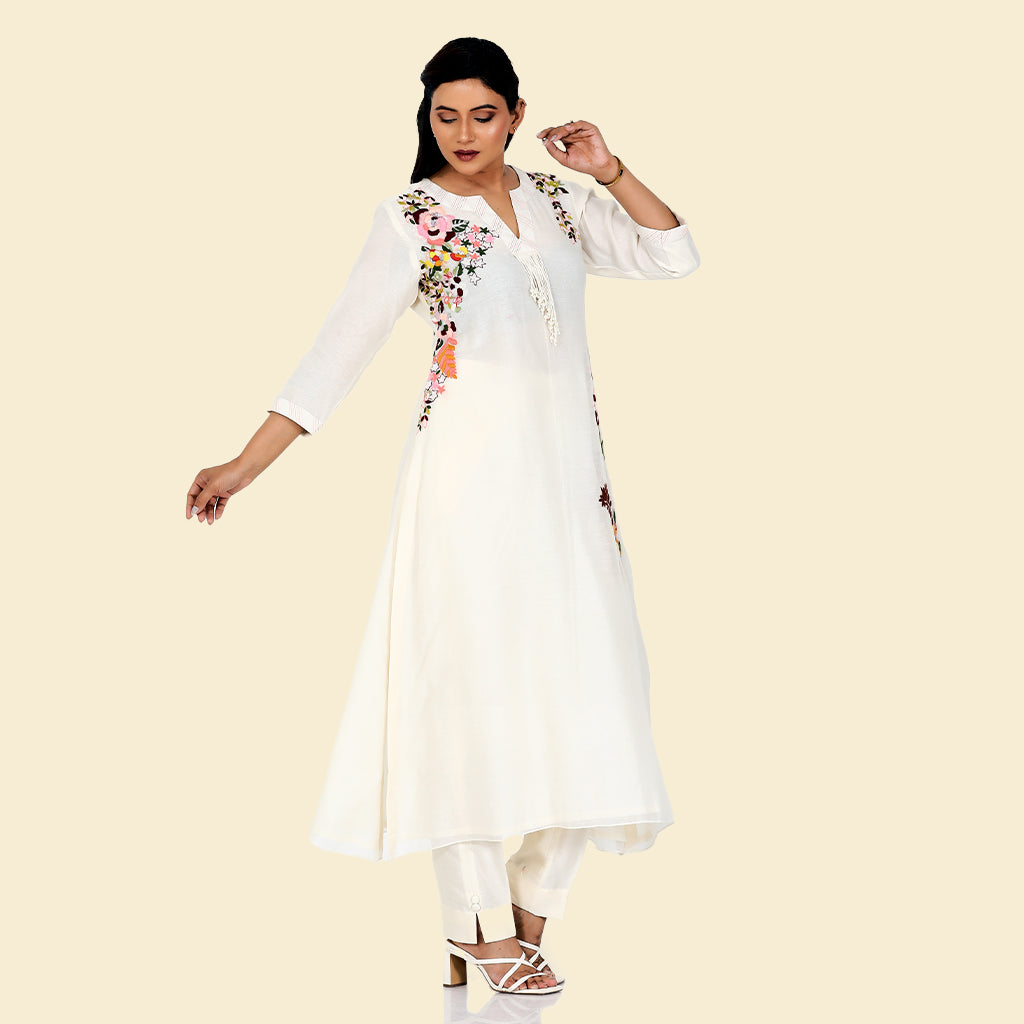 A woman standing and wearing white colored Ivory Floral Placement Kurta Set.