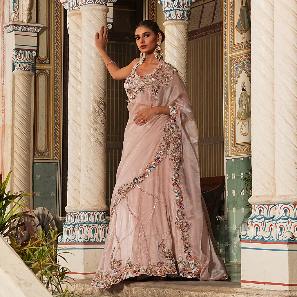 A woman wearing Blush Pink Colored Draped Saree.